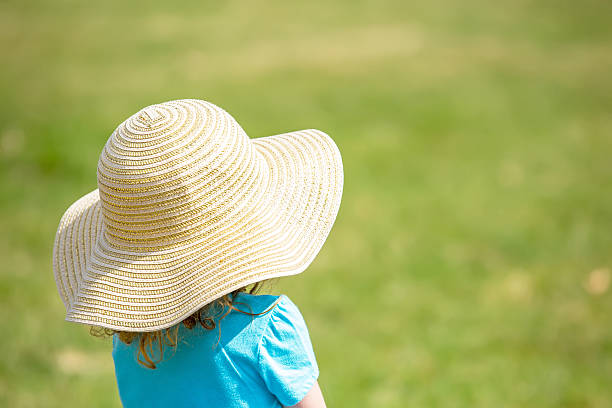 istock Little Girl in Sun Hat with Green Grass Copy Space 470328930