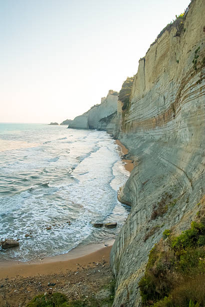 Loggas Beach with high cliffs and unusual rock formations in the north of the Greek island of Corfu. Picturesque scenery by the Ionian Sea. Greek landscapes. Seascape. Greece