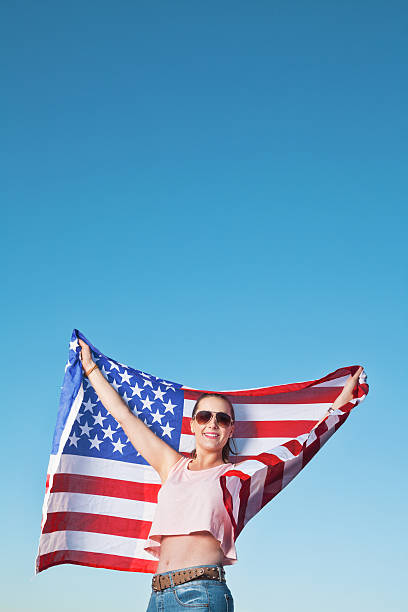 istock young female holding American flag 470329620