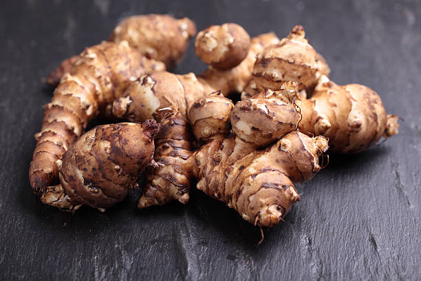 Jerusalem artichokes on a slate surface stock photo