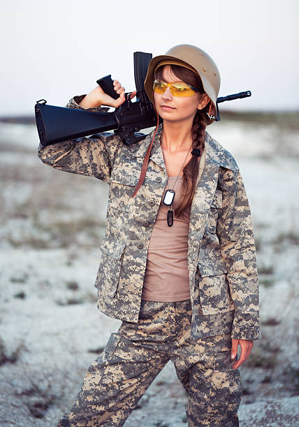 istock Young female soldier dressed in a camouflage with the gun 470337097