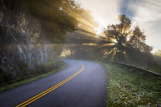 Blue Ridge Parkway North Carolina Sun Rays Blue Ridge Parkway North Carolina Sun Rays of Light beam through the trees along the road in the Appalachian Mountains in western NC blue ridge parkway stock pictures, royalty-free photos & images
