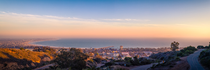 Ventura coastline panorama at sunset on a day hazy with marine layer, seen from the public Ventura Botanical Gardens in the hills beyond the Ventura city hall.