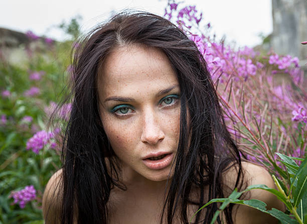 istock freckled girl among the flowers 470344909