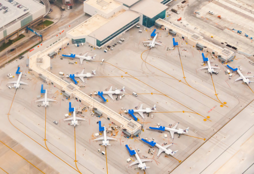 Ariel view of Airport scene with planes lined up at terminals , remote parking, taxiways, runways and airplanes ready to depart