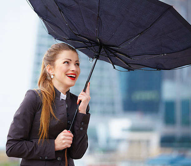 istock Woman with umbrella fighting strong wind 470349935