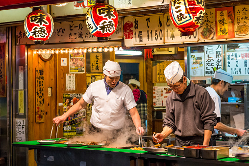 Osaka, Japan - December 27, 2014: Men cook traditional Japanese street food on December 27, 2014 in Osaka, Japan.