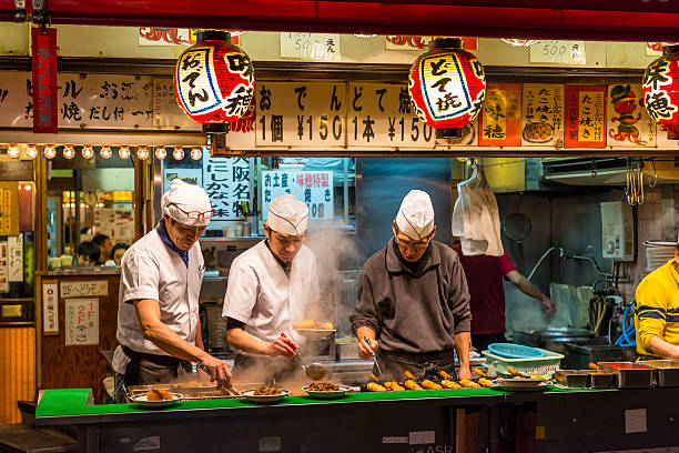 Late Night Dining Osaka, Japan - December 27, 2014: Men cook traditional Japanese street food on December 27, 2014 in Osaka, Japan. takoyaki photos stock pictures, royalty-free photos & images