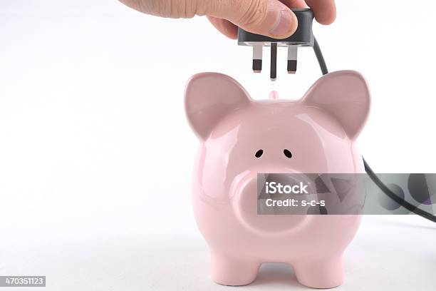 Hand Plugging An Electrical Cord Into A Pink Pig Piggy Bank Stock Photo - Download Image Now