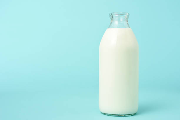 Opened blank milk bottle on blue background with copy space Opened blank milk bottle on cute blue background with copy space. milk bottle stock pictures, royalty-free photos & images