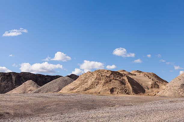 piles de gravier sur un site de construction sous un ciel bleu et lumineux - gravier photos et images de collection