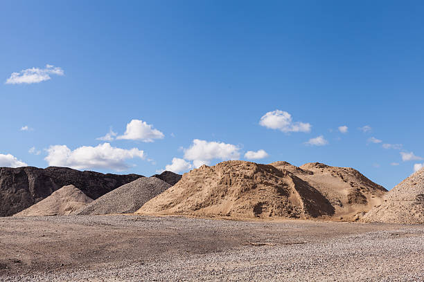 Piles of Gravel at Construction Site under Bright Blue Sky Piles of Gravel at Construction Site under Bright Blue Sky quarry stock pictures, royalty-free photos & images