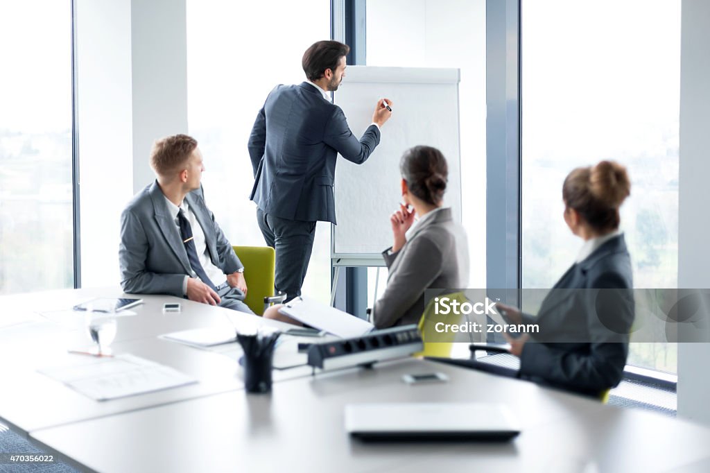 Business presentation Businessman holding presentation in board room, copy space Mergers and Acquisitions Stock Photo