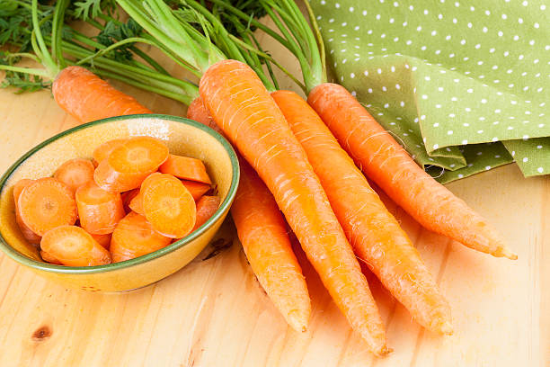 свежие морковь на деревянном фоне - carotene healthy eating macro close up стоковые фото и изображения