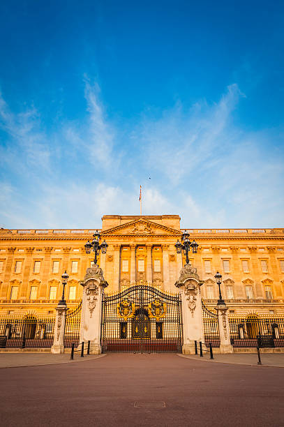 London golden dawn light on Buckingham Palace The Mall UK London, UK - 3rd May 2011: Warm dawn sunlight illuminated the iconic Portland stone facade, windows, balcony and ornate entrance gates of Buckingham Palace, London residence of the British Monarch, from the Victoria Memorial on The Mall. buckingham palace photos stock pictures, royalty-free photos & images