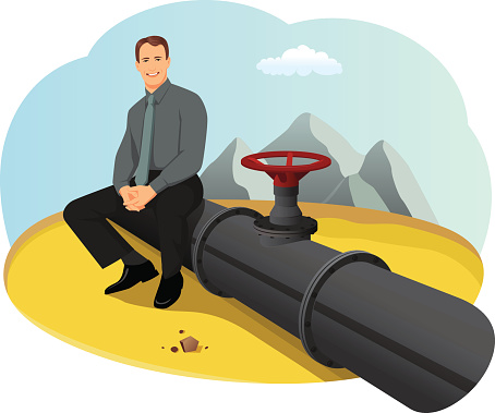 Happy businessman sitting on the oil pipeline in the desert