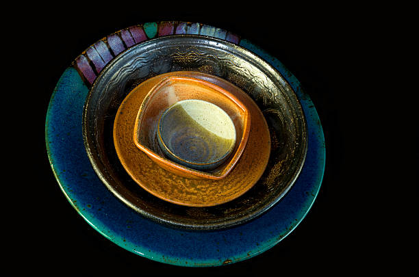 istock Many multicolored handcrafted bowls stacked together on a lack background. 470369014