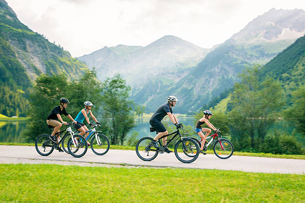 família de quatro ciclismo - blurred motion clothing mother offspring - fotografias e filmes do acervo