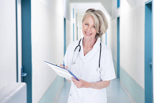 istock Female Doctor Writing Notes In Hospital Corridor 470370354