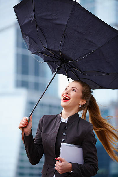 istock Woman with umbrella fighting strong wind 470370647
