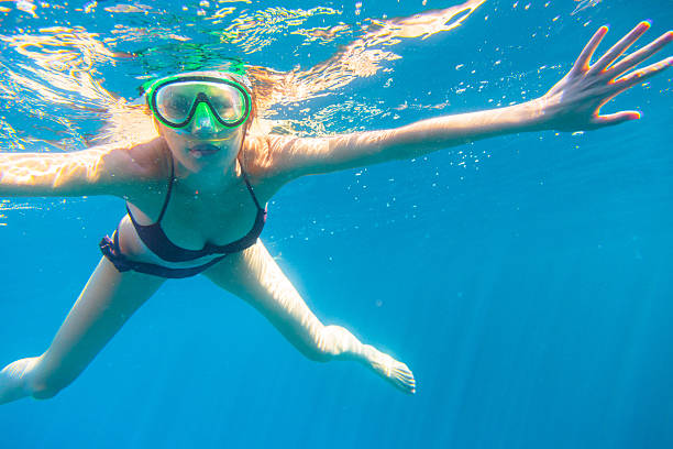 istock young woman snorkeling 470378475
