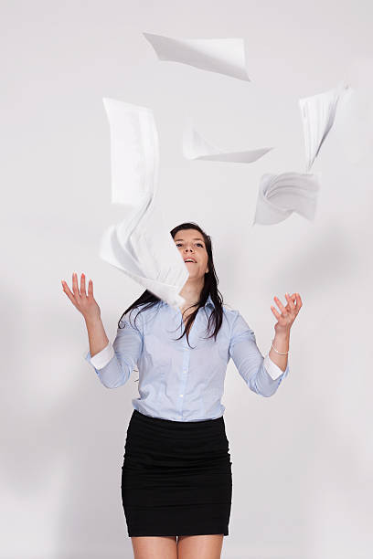 Woman throws out paper into the air stock photo