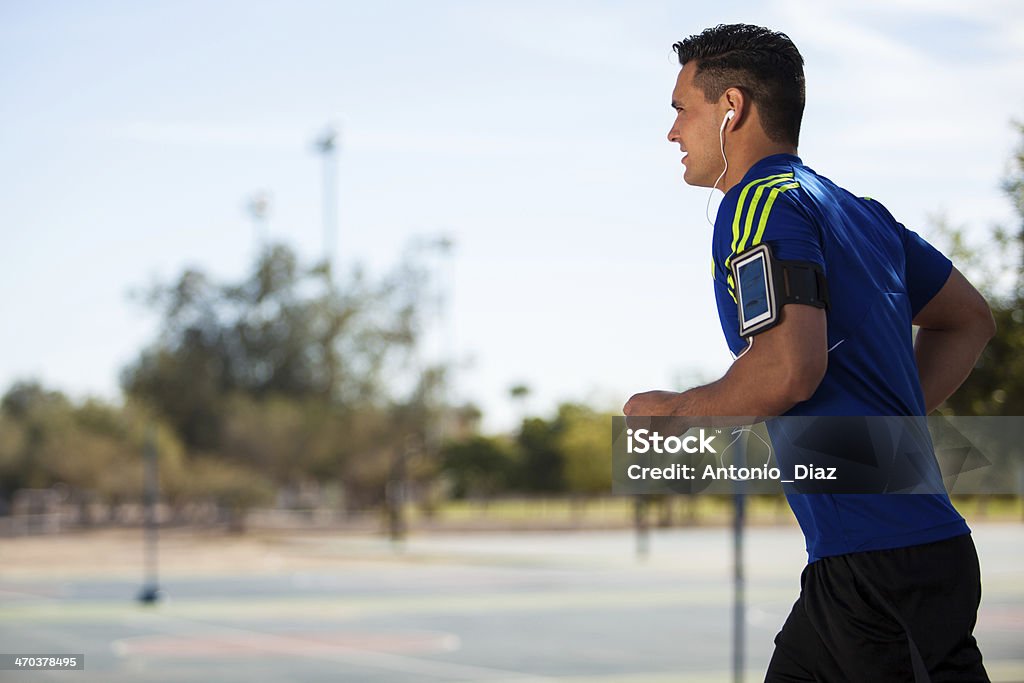 Athletic man running with music Young fit guy wearing his cell phone with and armband and running on a sunny day Jogging Stock Photo