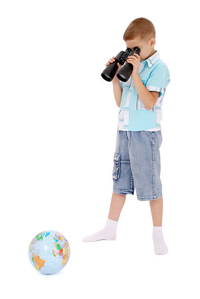 istock boy looks through the field-glass 470382948