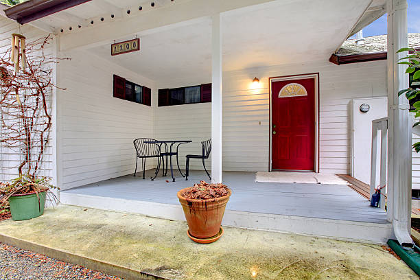 istock Nice porch with a red door and table set 470395703