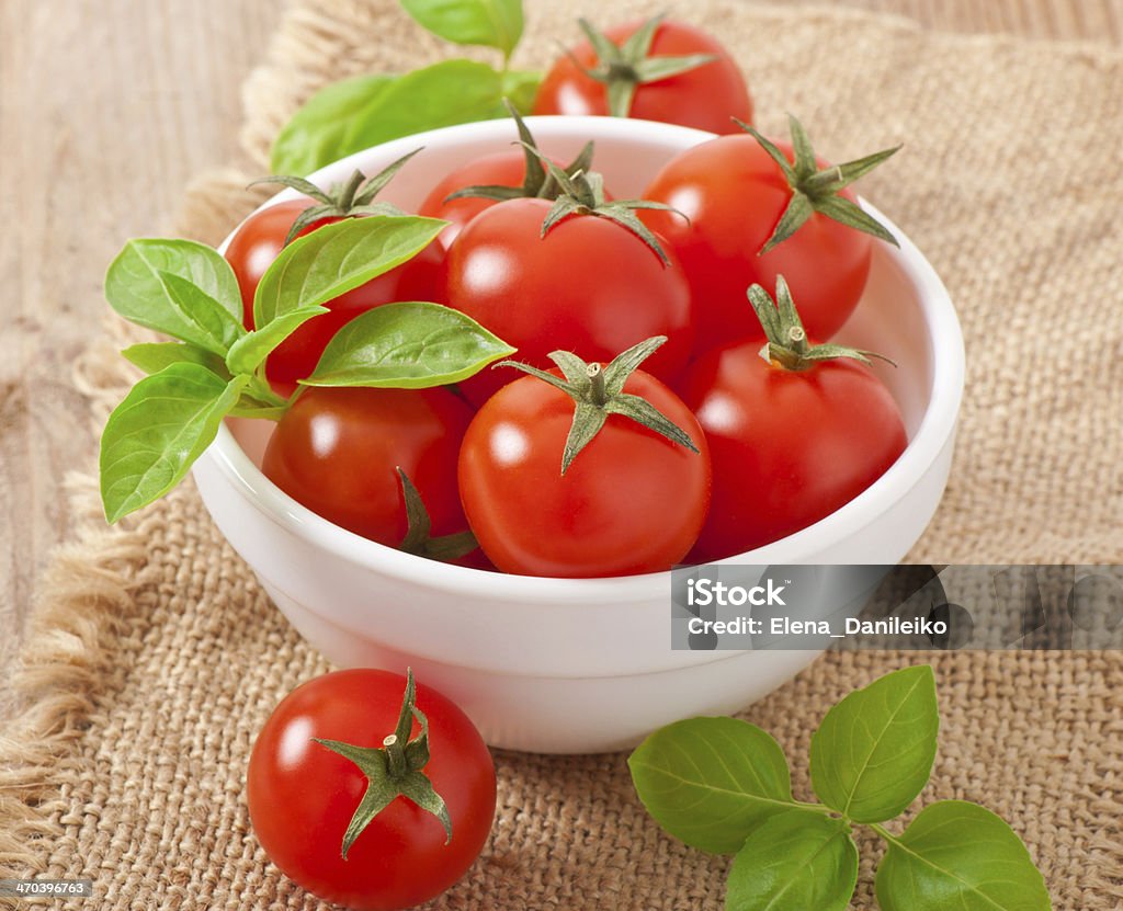 Cherry tomatoes in a bowl with basil Basil Stock Photo