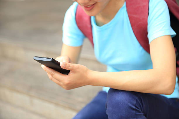 istock young woman using smart phone sit on stairs 470403492