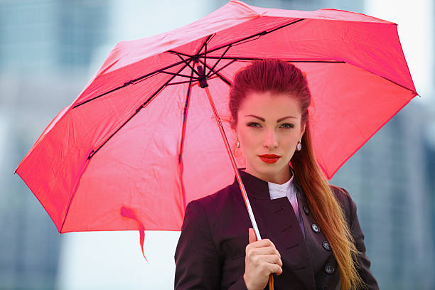 Young business woman with umbrella  http://azarubaika.com/iStockphoto/2012_11_05_Victoria_Business_Red.jpg