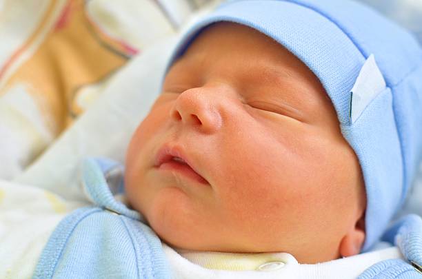 istock Dressed Up Infant Boy Quietly Sleeping in a Bed 470406436