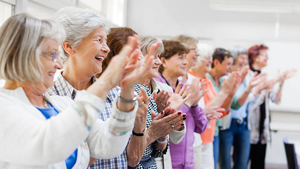 grupo de mujeres mayores ovacionar - senior adult group therapy social gathering community center fotografías e imágenes de stock