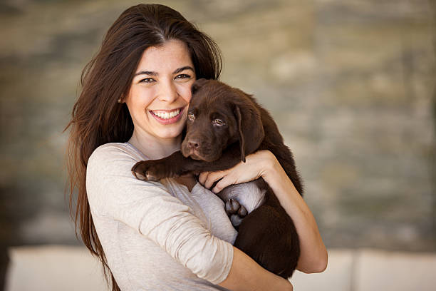 istock A smiling brunette lady holding a brown dog 470409261