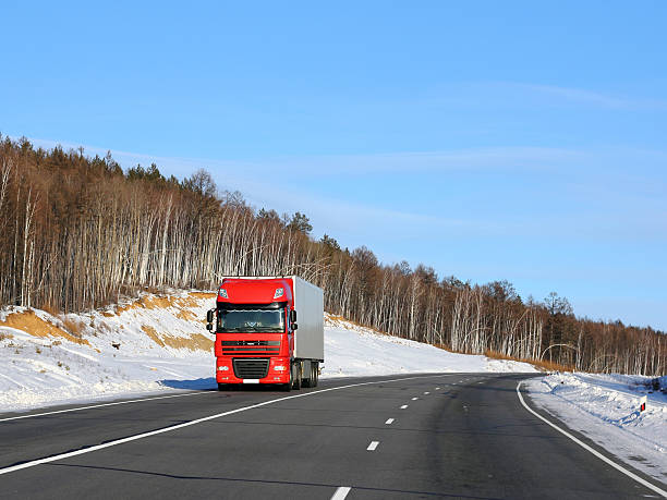 istock Large red truck on road with snow 470412877