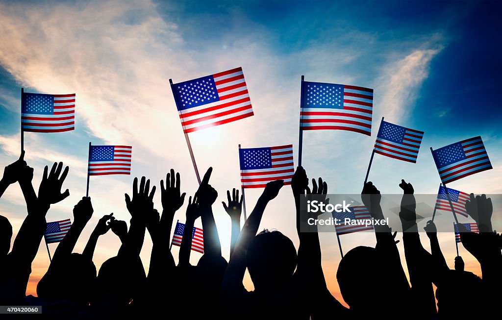 Group of People Waving American Flags in Back Lit USA Stock Photo