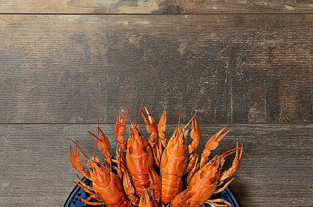 istock Plate of red crayfishes on old wooden table 470420132