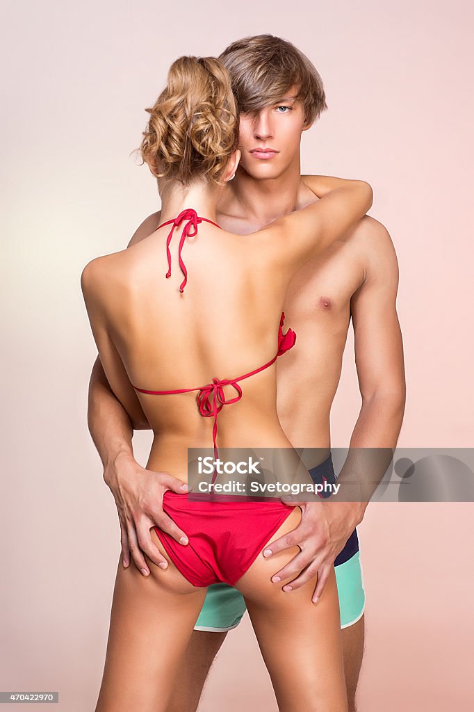 Beautiful couple in swimsuits Beautiful young woman in bikini with her handsome boyfriend. Passionate relationship, 2015 Stock Photo