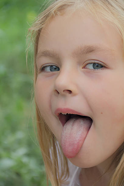 istock Small girl with put out tongue 470425619