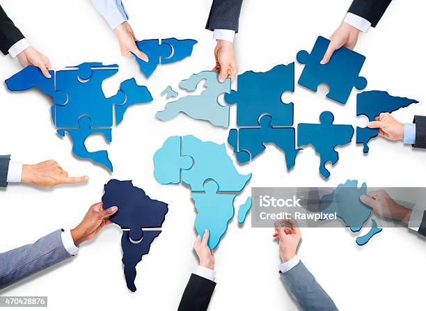 Hands Holding Out The Fitted Pieces Of A World Map Puzzle Stock Photo - Download Image Now