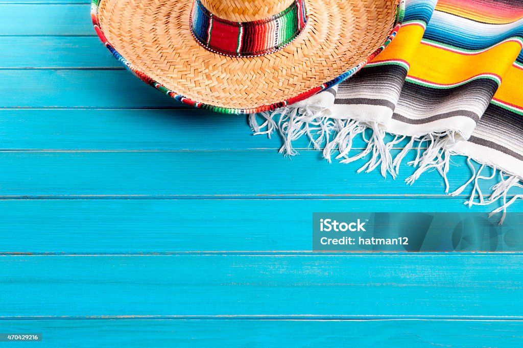 Mexican background with copyspace Mexican sombrero and traditional serape blanket laid on an old blue painted pine wood floor.  Space for copy. Mexican Culture Stock Photo