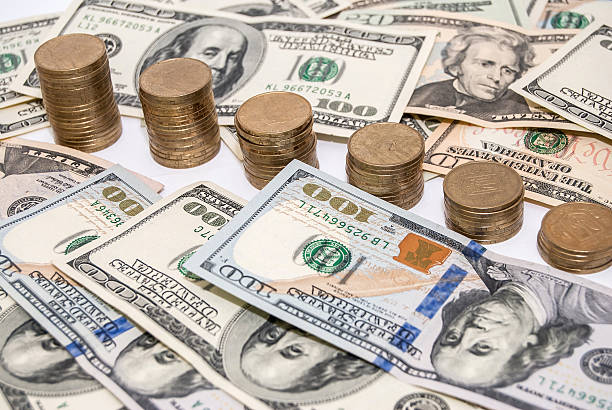 istock price graph coins and US dollar bills background 470429356