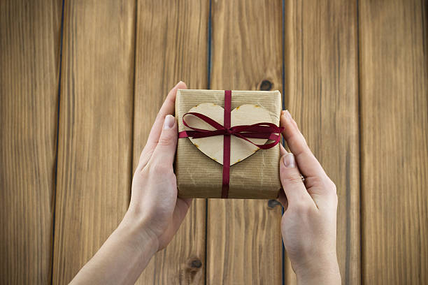istock Gift box with red ribbon in the hands 470430274