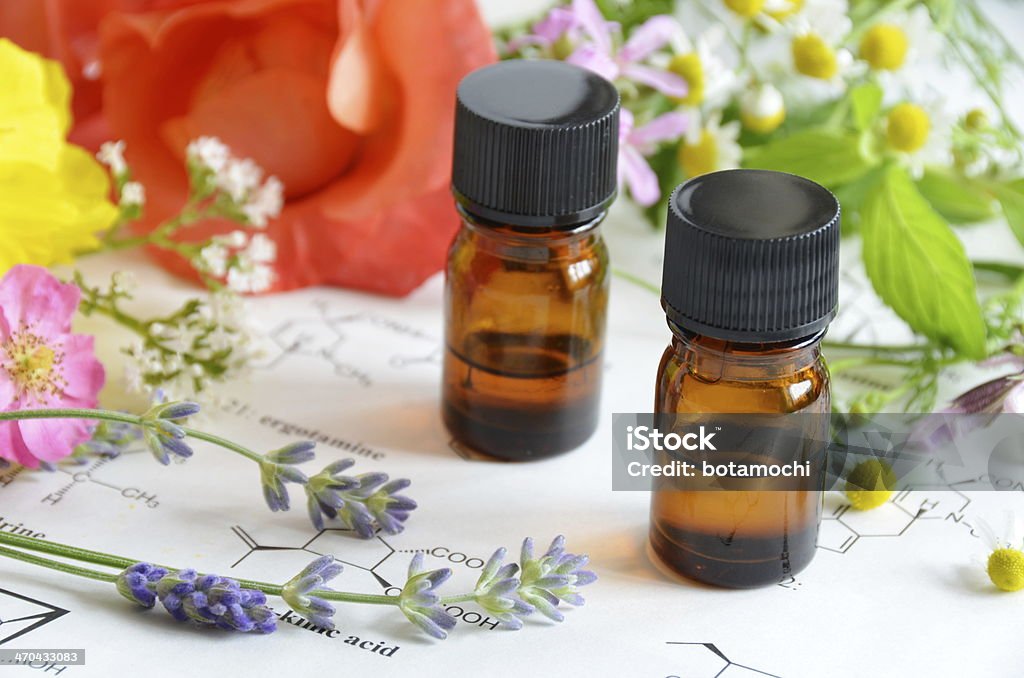 essential oils with herbal flowers essential oils with herbal flowers on science sheet Alternative Therapy Stock Photo
