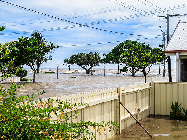 Flood waters across a suburban street The sea washing over the sea wall and flooding the street in Sandgate, Brisbane, Australia queensland floods stock pictures, royalty-free photos & images