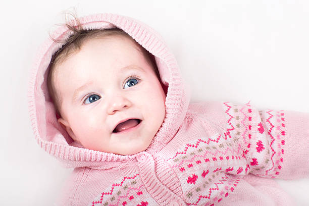 istock Funny baby girl in a pink jacket with hearts pattern 470436121