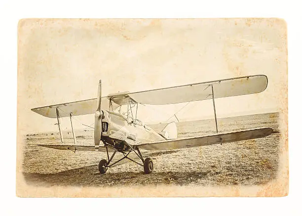 Biplane - vintage aircraft at paper background. Retro aviation concept - travel postcard on grunge style. Old airplane at the airfield.