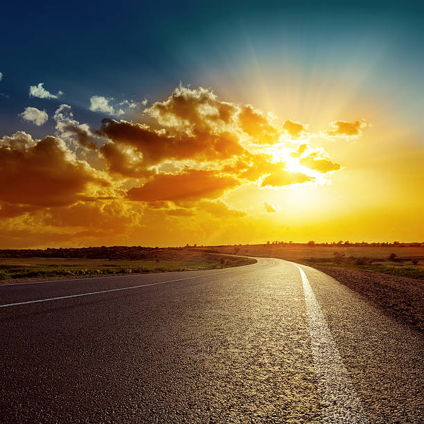 istock orange sunset over asphalt road 470438675