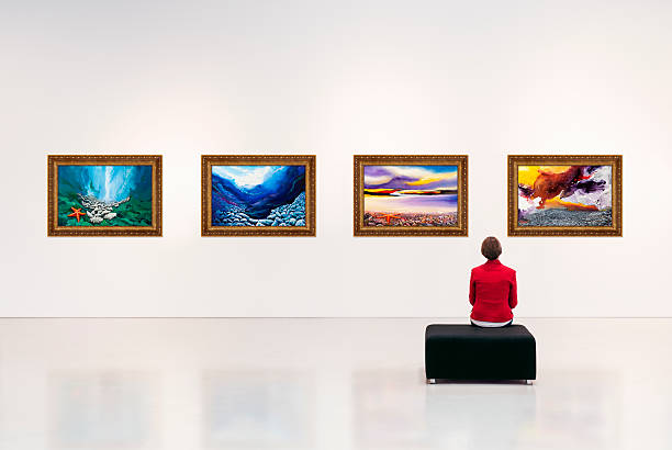 Art Gallery Exhibition centre, a visitor visits an art exhibition and looks at artist's collection on the wall. Documentation on file for artwork. fine art painting photos stock pictures, royalty-free photos & images